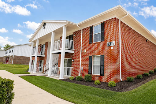 A red brick building with a white porch and a sign that says "1074".