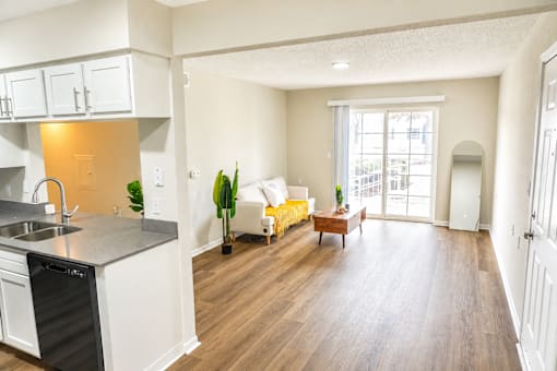 A kitchen with a sink, stove, and a dining table with chairs.
