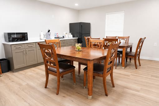 A kitchen with a table and chairs in the middle of the room.