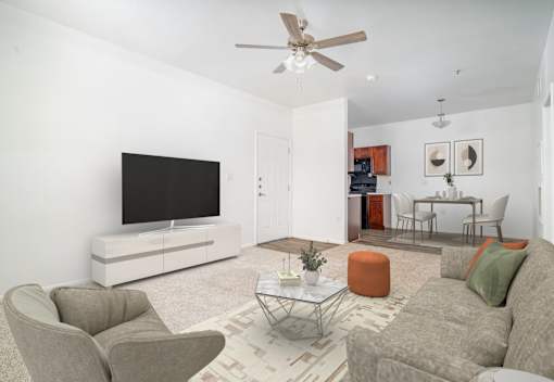 A living room with a grey couch, a white TV stand, and a glass coffee table.