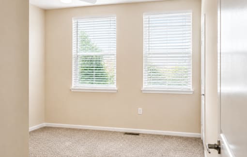 A room with a window and a carpet on the floor.