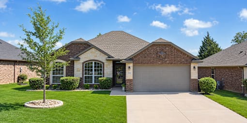 A house with a brown roof and a grey garage door.