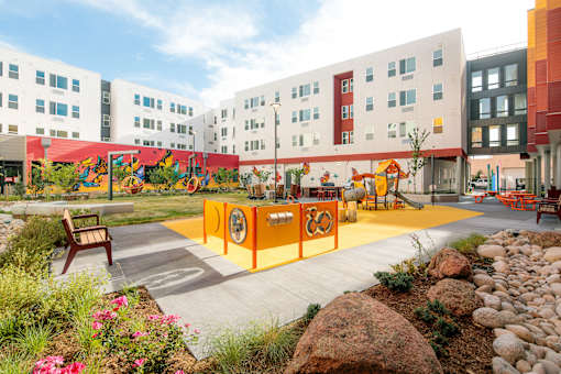 A playground area with a slide and a rock wall.
