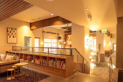 A room with a wooden bookshelf and a glass railing.