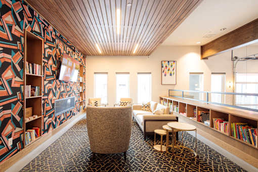 A room with a patterned wallpaper and a wooden ceiling.
