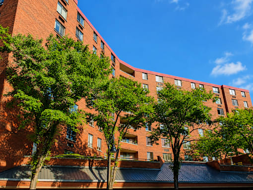 A red brick building with trees in front.