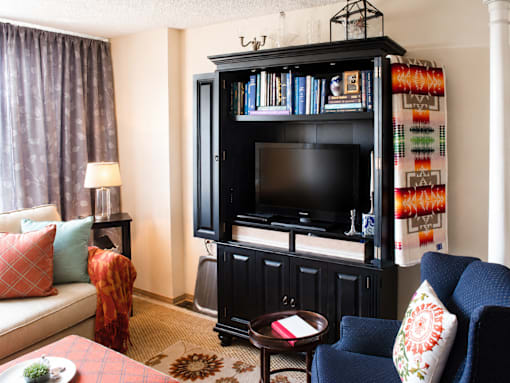 A living room with a black entertainment center and a blue chair.
