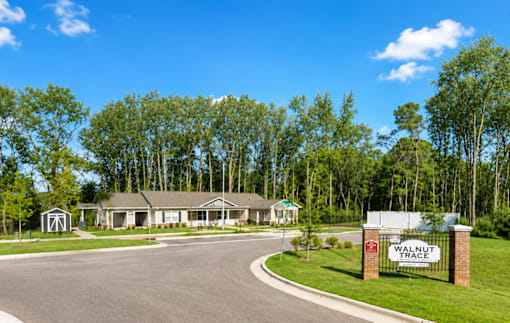 A Walnut Grove sign is in front of a grassy area.