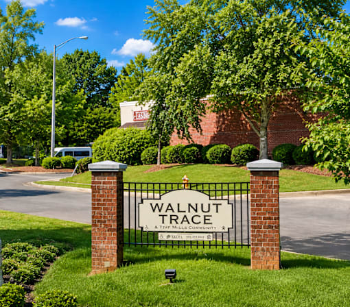 A sign that says Walnut Trace stands in front of a grassy area.