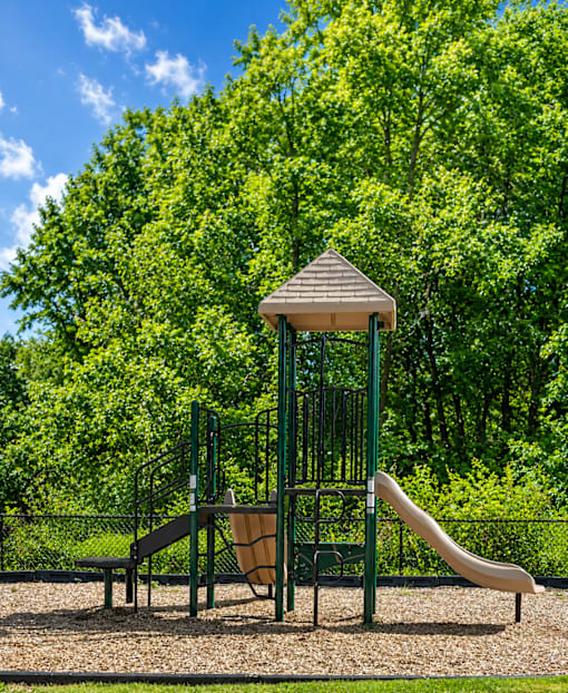 A playground with a slide, swings, and a gazebo.