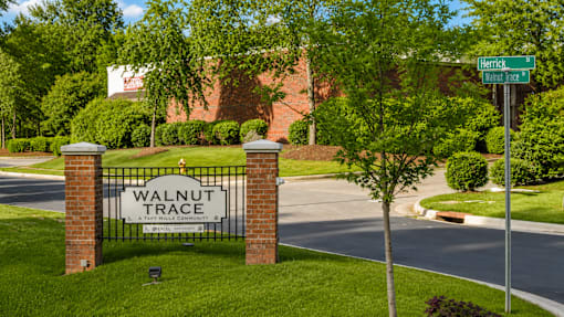 A sign that says Walnut Trace stands in front of a street.