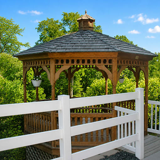 A gazebo with a white fence in front of it.
