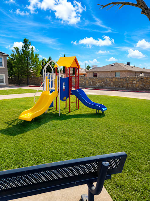 A playground with a yellow and blue slide.