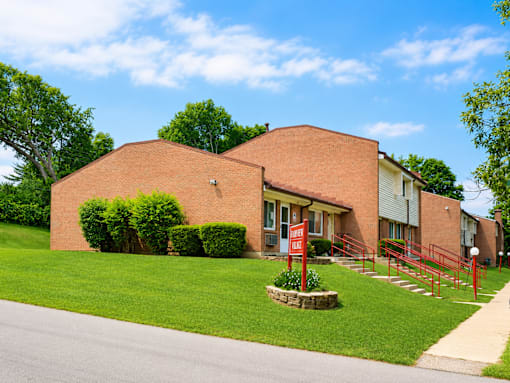 A red brick building with a red gate in front.