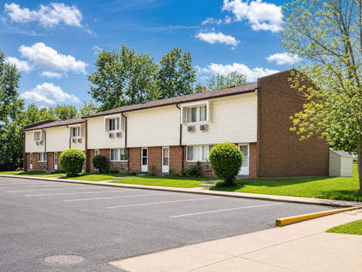 A row of houses with a parking lot in front.