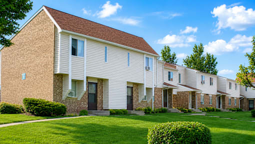 A row of houses with brown roofs and white walls.