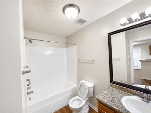 A white bathroom with a toilet, sink, and bathtub.