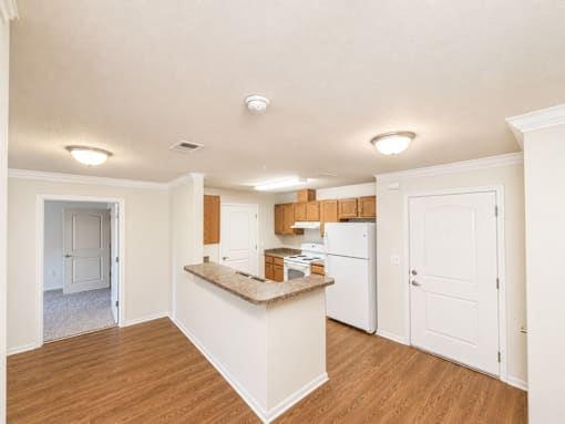A kitchen with white appliances and wooden cabinets.