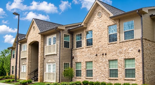 A large, multi-story residential building with a stone facade and multiple windows.