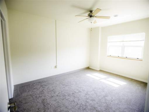 A room with a ceiling fan and a window.