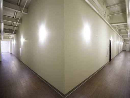 A long hallway with a light on the wall.