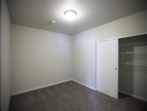 A room with a white door and a light on the ceiling.