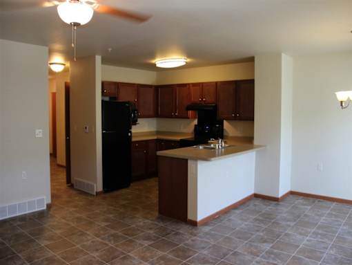 A kitchen with brown cabinets and black appliances.