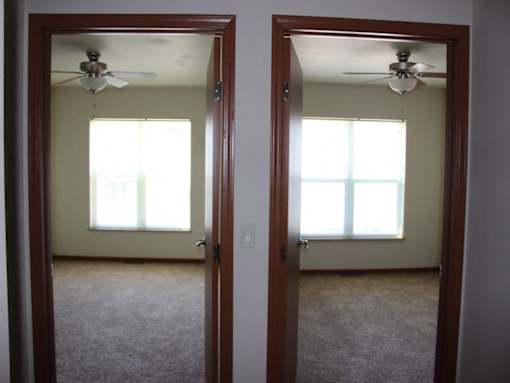 Two rooms with carpet floors and ceiling fans.