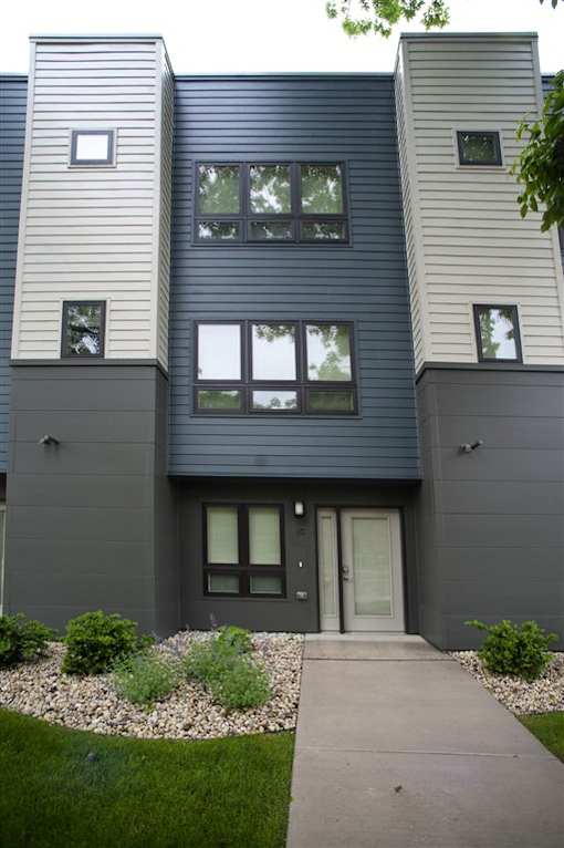 A modern house with a grey front and a small garden.