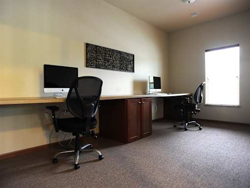 A room with a desk and two chairs.