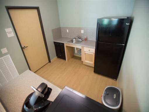 A small kitchen with a black fridge and a sink.