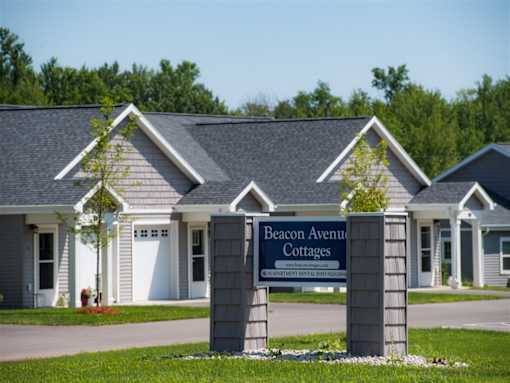 The image shows a sign for Beacon Avenue Cottages in front of a building.