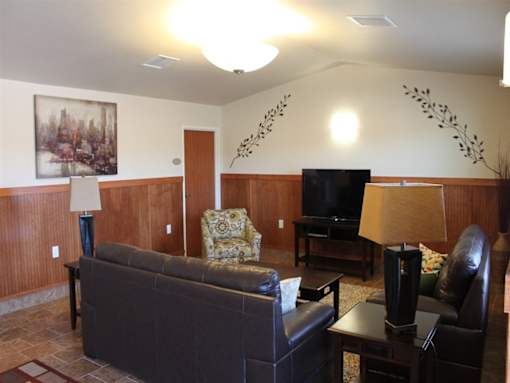 A living room with a couch, chair, and television.