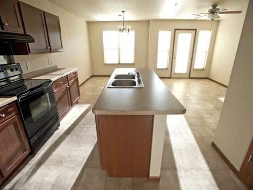 A kitchen with a black oven and wooden cabinets.
