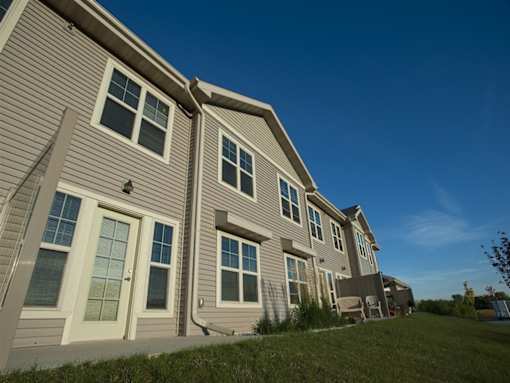 A row of houses with grey siding and white trim.