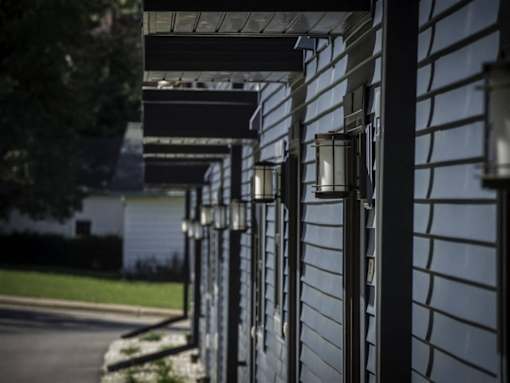 A row of black lampposts line a sidewalk.
