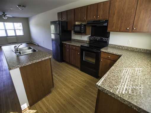 A kitchen with wooden cabinets and black appliances.