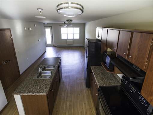 A kitchen with wooden cabinets and a black stove top oven.