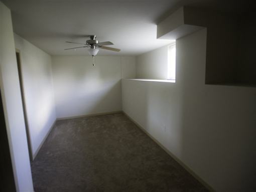 A room with a ceiling fan and a window.