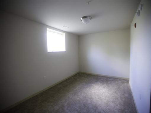 A room with a window and carpeted floor.