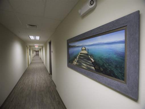A long hallway with a picture of a bridge on the wall.