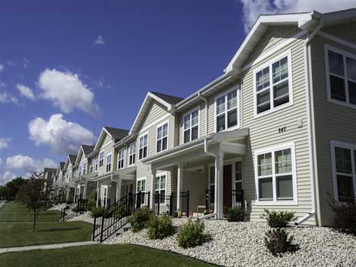 A row of houses with a blue sky in the background.