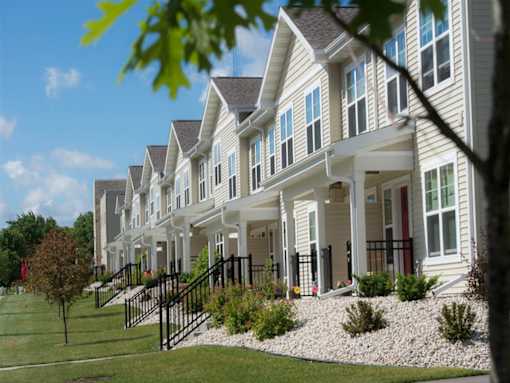 A row of houses with a tree in the foreground.