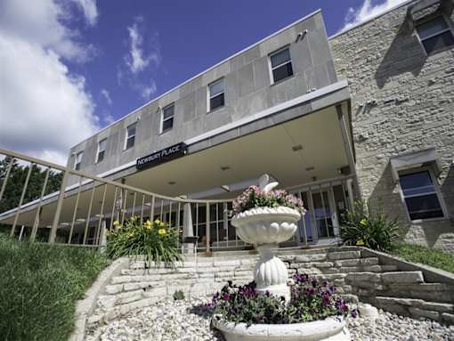 A stone building with a white awning and a fountain in front.