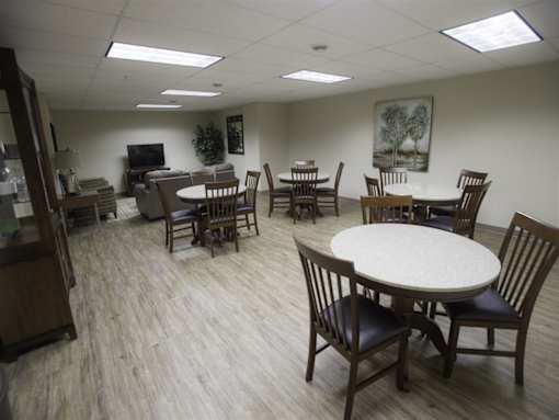 A room with a white table surrounded by chairs.