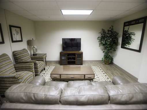 A living room with a grey couch and a television.