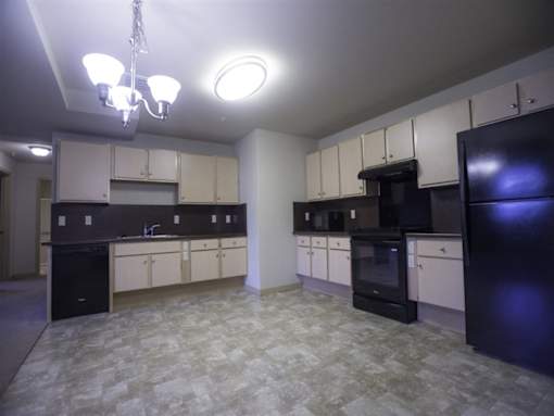 A kitchen with black appliances and white cabinets.