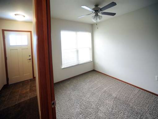 A room with a ceiling fan and a window.