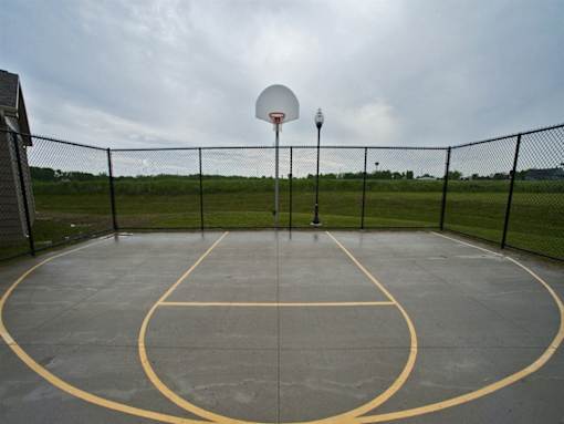 A basketball court with a basketball hoop and a light pole.