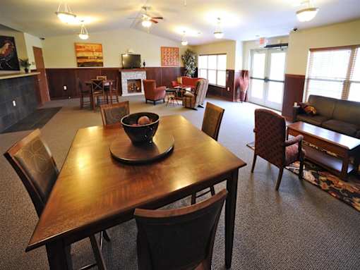 A dining room with a wooden table and chairs.